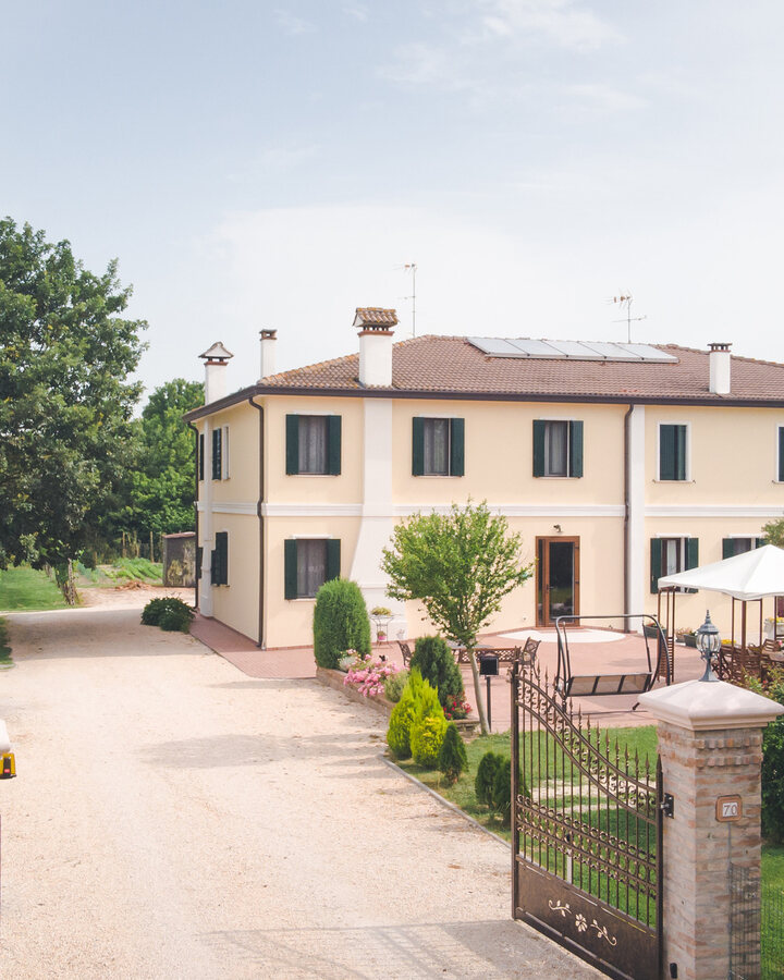 La casa di Corte Burchio con il viale d'ingresso e il cancello