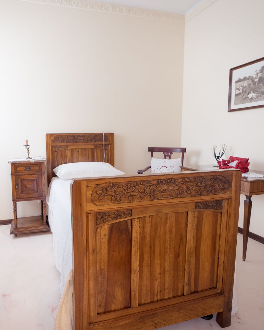 Camera El Granaro con letto singolo in legno intagliato e comodino d'epoca