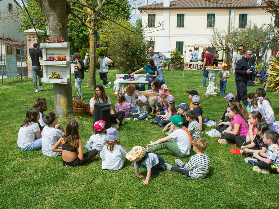 Bambini seduti sul prato durante una visita della fattoria didattica
