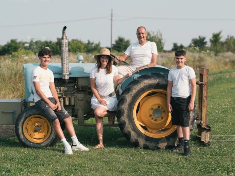 La famiglia sul trattore d'epoca tra i campi